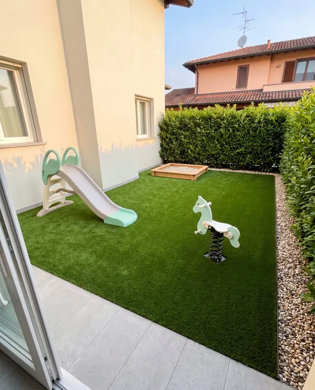 Giardino di 30 m² in prato sintetico a Nerviano con cadute e pioggia senza diventare fango, siepe di lauro