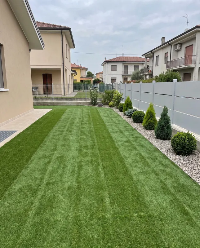 Giardino di 300 m² a Cusago con bordure in ghiaia, siepi che chiudono la vista sul vicino
